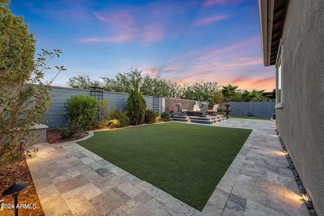 yard at dusk with a patio area