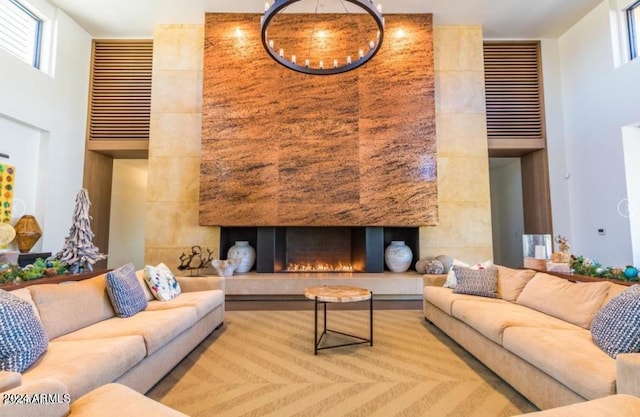 living room with a tile fireplace and a towering ceiling