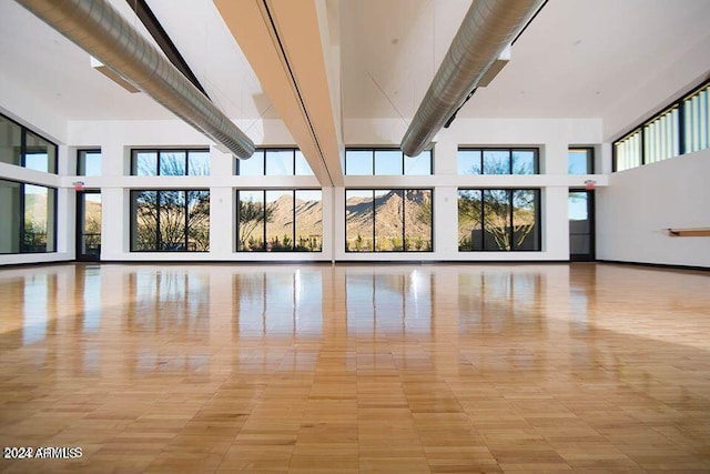 unfurnished living room featuring a towering ceiling and plenty of natural light