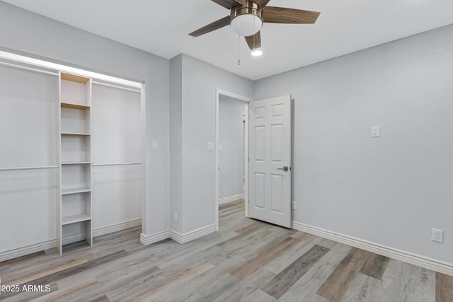 unfurnished bedroom with ceiling fan, light wood-type flooring, and a closet