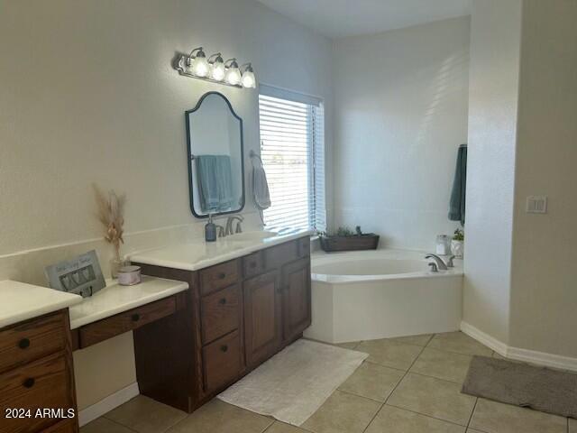 bathroom with tile patterned floors, vanity, and a tub to relax in