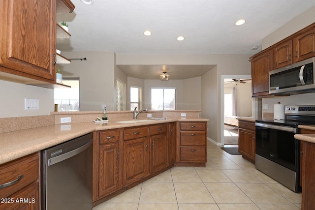 kitchen featuring light tile patterned floors, stainless steel appliances, ceiling fan, and sink