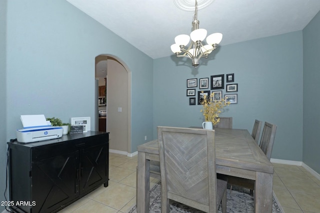 tiled dining room featuring an inviting chandelier