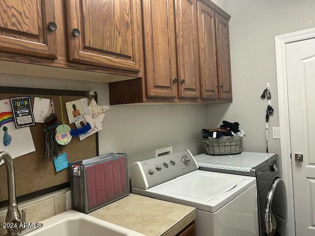 washroom featuring cabinets, independent washer and dryer, and sink