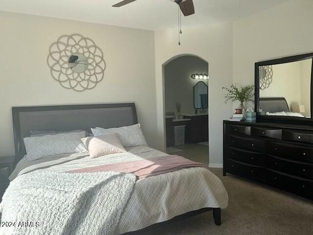 carpeted bedroom featuring ensuite bath and ceiling fan