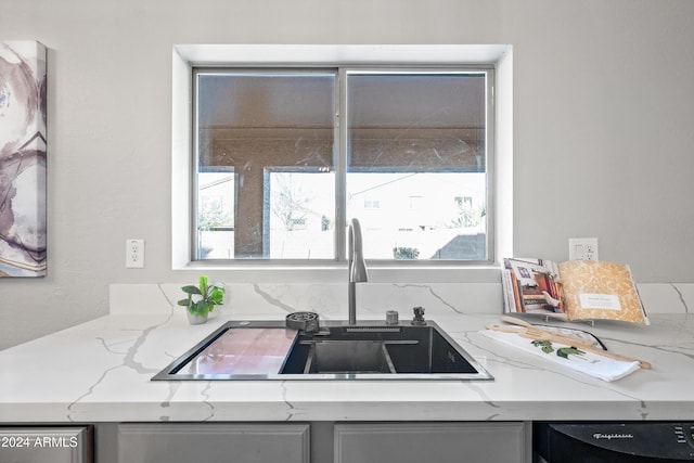 kitchen with sink, plenty of natural light, dishwasher, and light stone counters