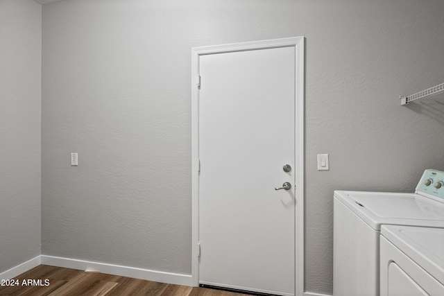 laundry area featuring separate washer and dryer and hardwood / wood-style flooring