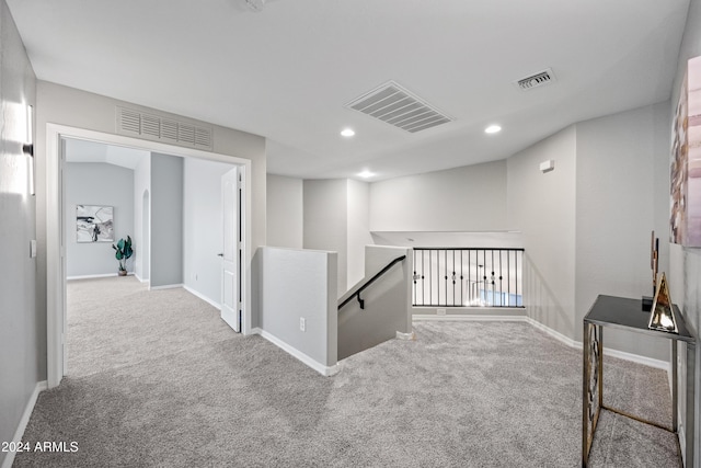 hallway featuring light colored carpet