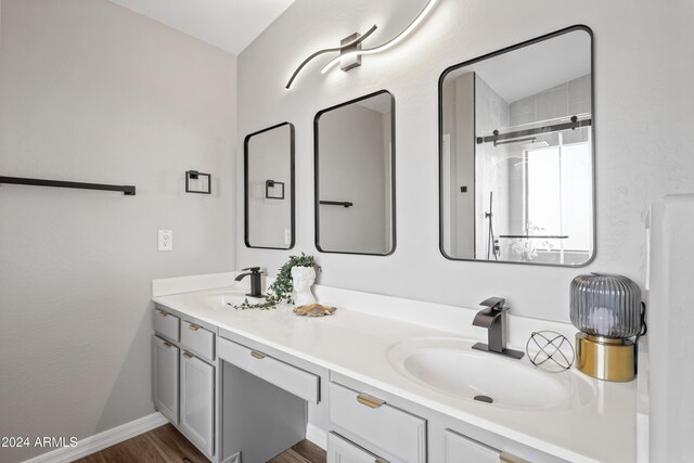 bathroom with vanity, wood-type flooring, and a shower with shower door