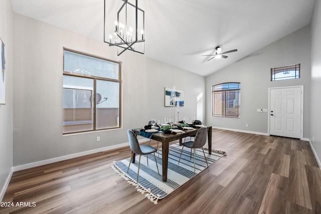 dining space featuring lofted ceiling, wood-type flooring, and ceiling fan with notable chandelier