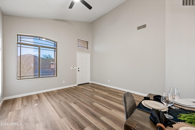 unfurnished office featuring ceiling fan, light hardwood / wood-style floors, and high vaulted ceiling