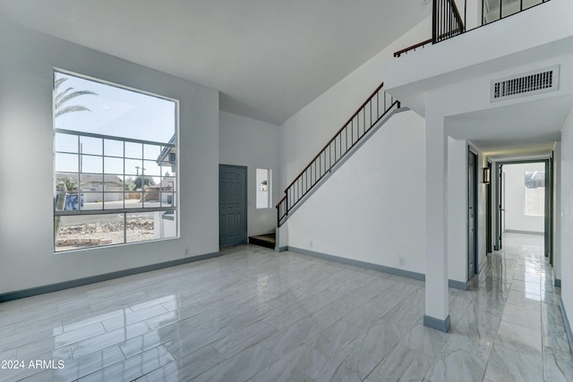 unfurnished living room featuring high vaulted ceiling