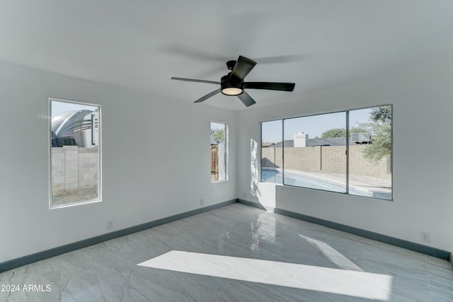 spare room featuring plenty of natural light and ceiling fan