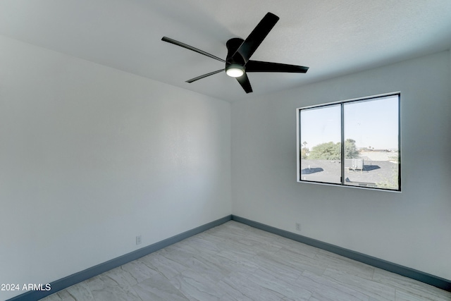 unfurnished room with ceiling fan and a textured ceiling