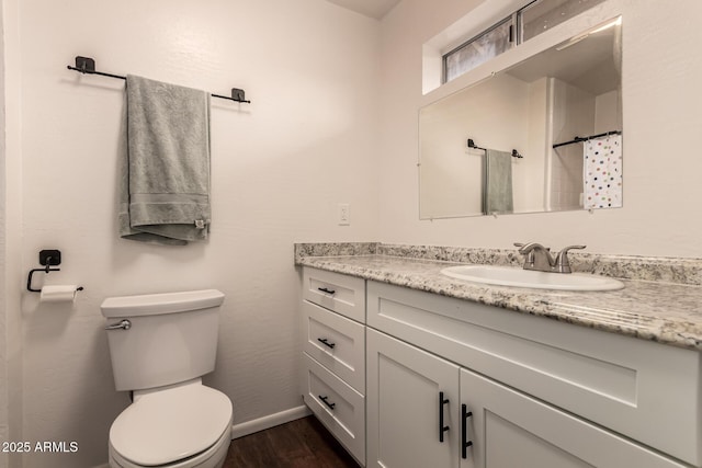 bathroom with baseboards, toilet, a shower with curtain, wood finished floors, and vanity