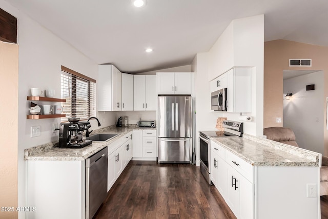 kitchen with a sink, stainless steel appliances, visible vents, and vaulted ceiling