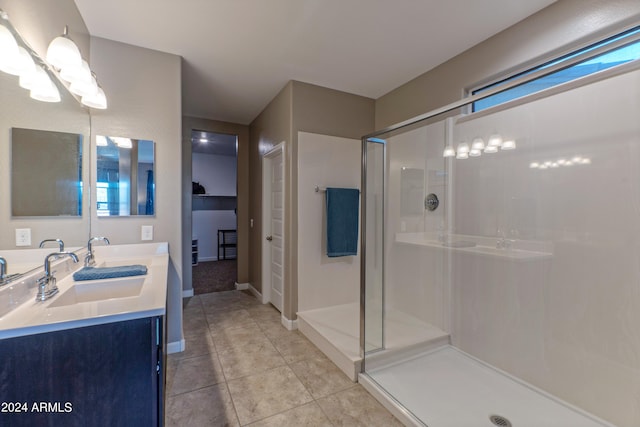 bathroom with a shower with door, vanity, and tile patterned flooring