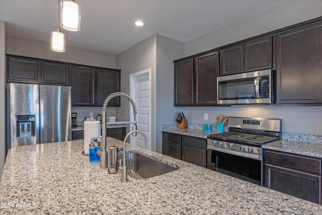 kitchen with light stone counters, stainless steel appliances, and dark brown cabinetry