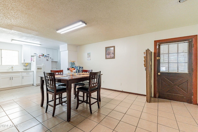 tiled dining space featuring sink and a textured ceiling