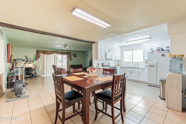 tiled dining room featuring sink and a textured ceiling