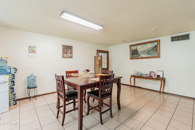 tiled dining space featuring a textured ceiling