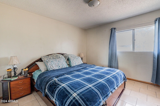 bedroom with light tile patterned floors and a textured ceiling