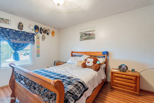 bedroom with wood-type flooring and a textured ceiling