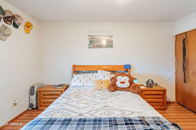 bedroom featuring a closet, hardwood / wood-style floors, and a textured ceiling