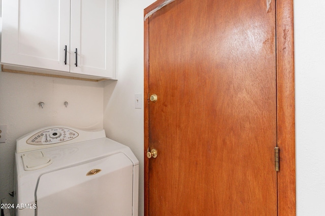 clothes washing area with cabinets and washer / dryer