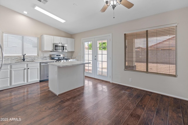 9231 W Grovers Ave, Peoria, AZ 85382 - kitchen featuring appliances with stainless steel finishes, a sink, lofted ceiling, a kitchen island, and white cabinetry