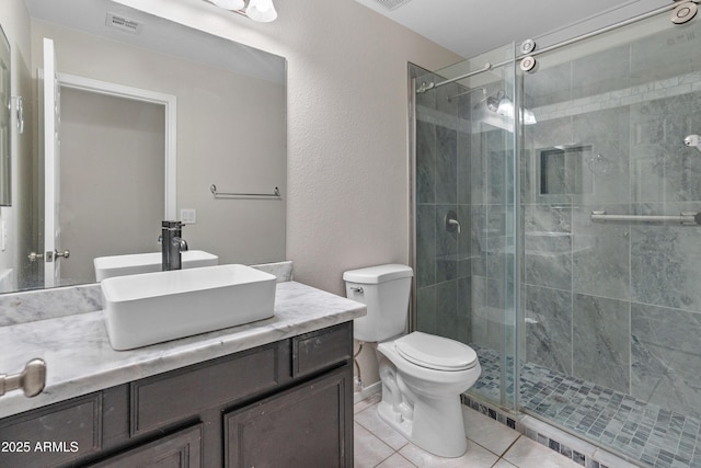 9231 W Grovers Ave, Peoria, AZ 85382 - full bath with vanity, toilet, a shower stall, tile patterned flooring, and a textured wall