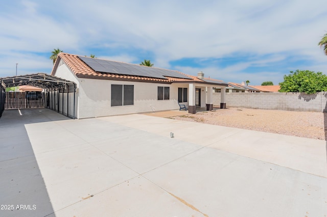 9231 W Grovers Ave, Peoria, AZ 85382 - back of house with a detached carport, stucco siding, roof mounted solar panels, and a tile roof