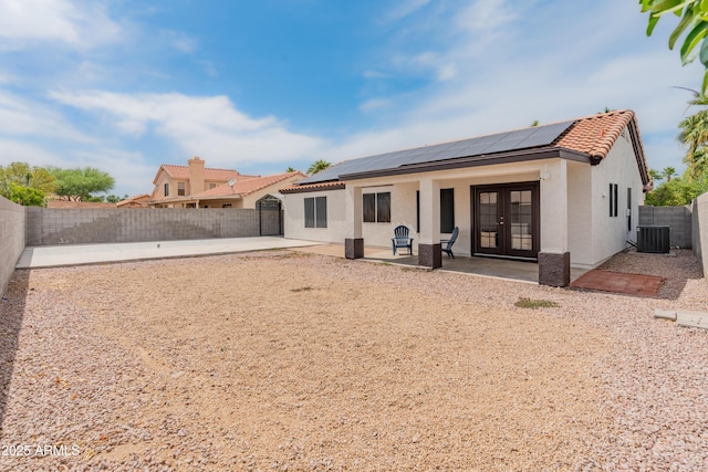 9231 W Grovers Ave, Peoria, AZ 85382 - rear view of property featuring french doors, a patio area, solar panels, stucco siding, and a fenced backyard