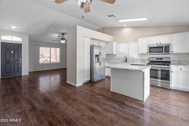 9231 W Grovers Ave, Peoria, AZ 85382 - kitchen featuring appliances with stainless steel finishes, a ceiling fan, vaulted ceiling, open floor plan, and white cabinets