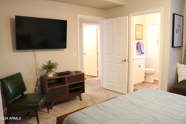 bedroom featuring light carpet and connected bathroom