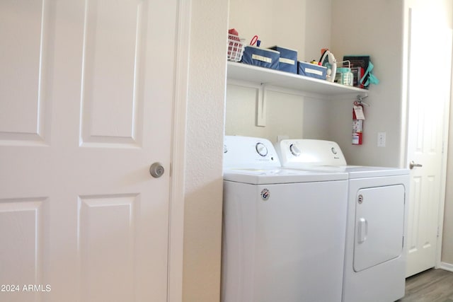 laundry area featuring laundry area, washing machine and clothes dryer, and light wood-style floors