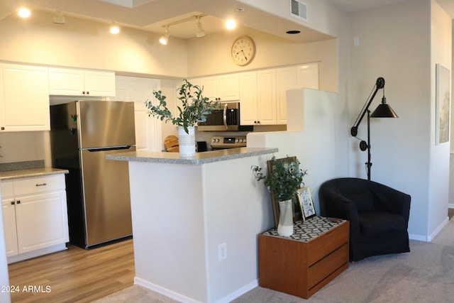 kitchen with light countertops, appliances with stainless steel finishes, visible vents, and white cabinets