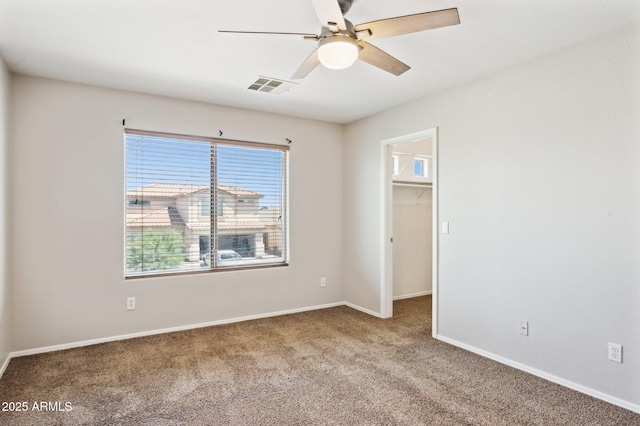 carpeted empty room with ceiling fan and baseboards
