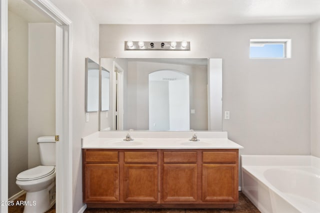full bathroom with a garden tub, double vanity, and toilet