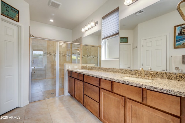 bathroom featuring tile patterned floors, a shower with shower door, and vanity