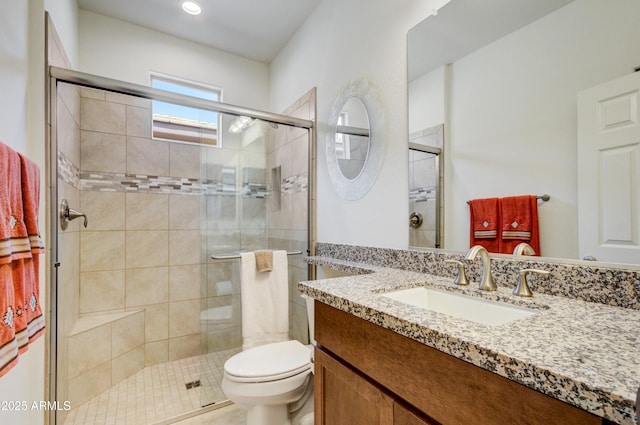 bathroom with vanity, an enclosed shower, and toilet