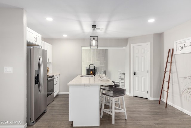 kitchen featuring white cabinets, sink, hanging light fixtures, an island with sink, and stainless steel appliances