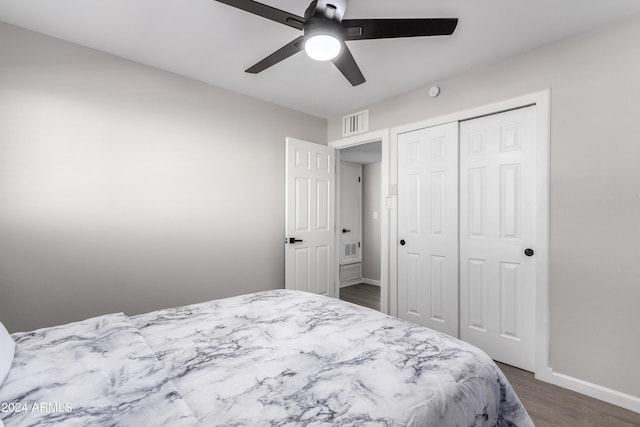 bedroom featuring dark hardwood / wood-style flooring, ceiling fan, and a closet