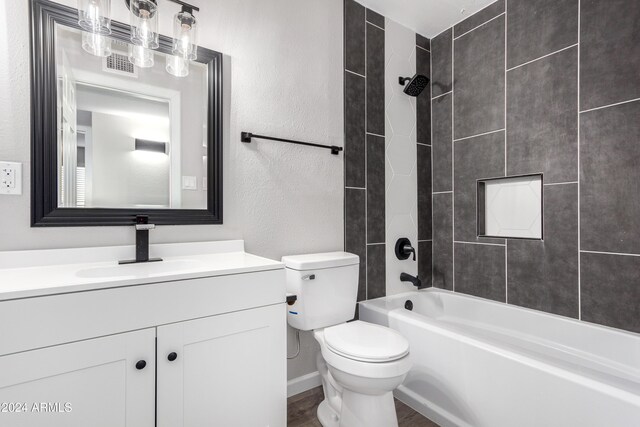 full bathroom featuring vanity, tiled shower / bath combo, and toilet