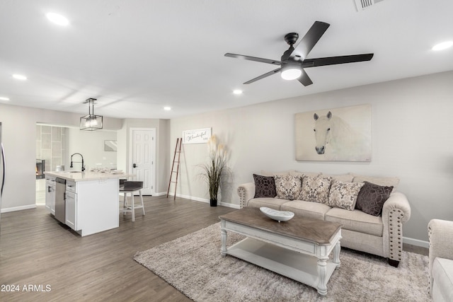 living room with hardwood / wood-style flooring, ceiling fan, and sink