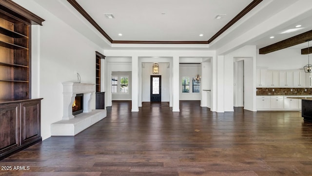 unfurnished living room featuring dark hardwood / wood-style floors and ornamental molding