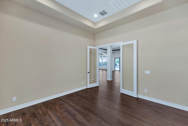 spare room featuring dark hardwood / wood-style flooring and french doors