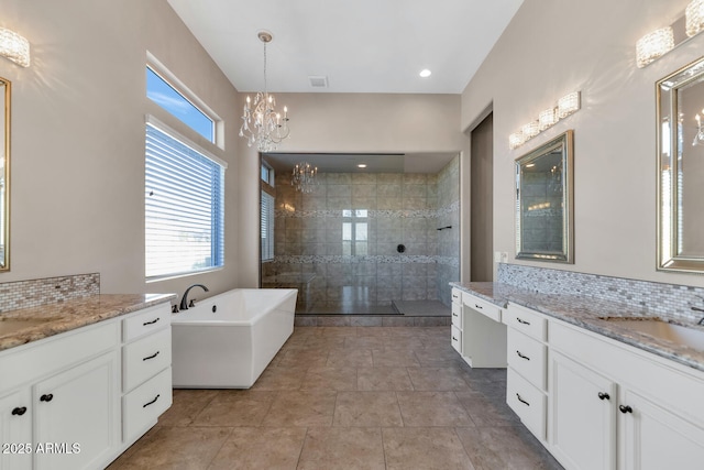 bathroom featuring decorative backsplash, shower with separate bathtub, vanity, and an inviting chandelier