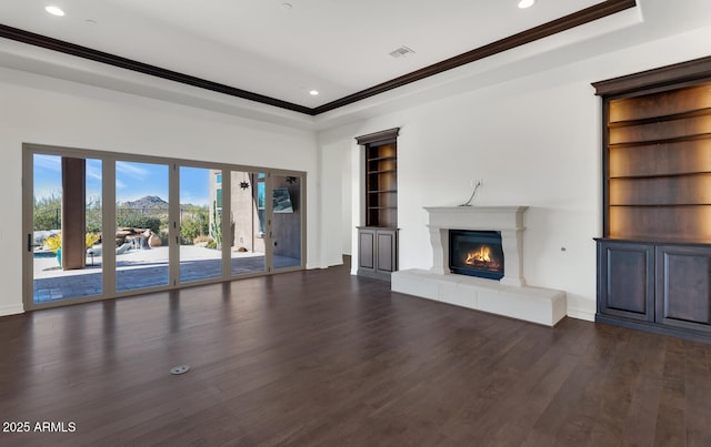 unfurnished living room featuring built in shelves, dark hardwood / wood-style flooring, and crown molding