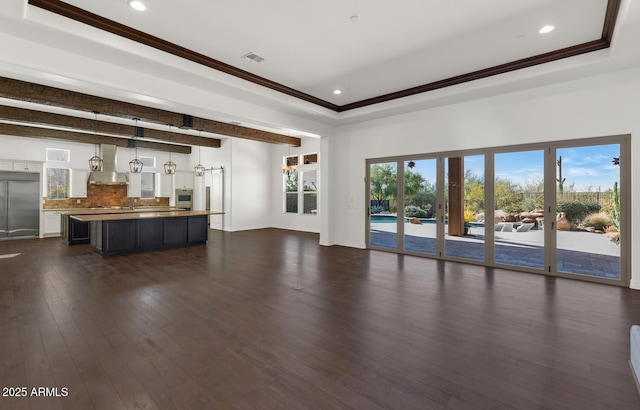 unfurnished living room with ornamental molding, dark wood-type flooring, and a wealth of natural light